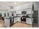 A bright kitchen with stainless steel appliances, an island with bar seating, and a view to the dining area at 11035 E Clinton St, Scottsdale, AZ 85259