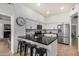 A kitchen features a black marble island with seating, stainless steel appliances, and white cabinets at 11035 E Clinton St, Scottsdale, AZ 85259