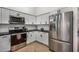 A brightly lit kitchen features stainless steel appliances, white cabinets, and black countertops at 11035 E Clinton St, Scottsdale, AZ 85259