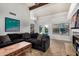 Stylish living room with a dark sofa, fireplace, and sliding doors leading to the pool area at 11035 E Clinton St, Scottsdale, AZ 85259