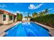 A backyard pool features sparkling blue water and is surrounded by mature landscaping and privacy hedges at 11035 E Clinton St, Scottsdale, AZ 85259