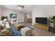 Bright living room features a ceiling fan, wood floors, an area rug, and a flatscreen TV atop a wooden credenza at 2633 W Ocotillo Rd # 3, Phoenix, AZ 85017