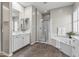 This bathroom features double sinks, large mirror, separate tub and shower, and brown tile flooring at 2229 N Beverly Pl, Buckeye, AZ 85396