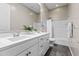 Bright bathroom featuring double sinks with white cabinets, large mirror, and shower with curtain at 2229 N Beverly Pl, Buckeye, AZ 85396