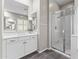 This bathroom features double sinks, large mirror, a glass shower, and brown tile flooring at 2229 N Beverly Pl, Buckeye, AZ 85396