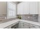 Kitchen area features built in white cabinetry and desk area with mosaic backsplash at 2229 N Beverly Pl, Buckeye, AZ 85396