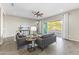Bright living room featuring cozy sofas, a modern ceiling fan, and a view of the pool at 2229 N Beverly Pl, Buckeye, AZ 85396