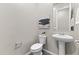 This powder room features a modern pedestal sink, a toilet, and unique wall decor at 2229 N Beverly Pl, Buckeye, AZ 85396
