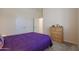 Cozy bedroom with purple bedding and wicker dresser at 14133 S 179Th Ave, Goodyear, AZ 85338