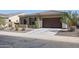 Tan house with brown garage door and landscaping at 14133 S 179Th Ave, Goodyear, AZ 85338