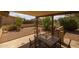 Covered patio features a table with four chairs and low maintenance landscaping with desert plants and gravel at 1729 Leisure World --, Mesa, AZ 85206