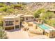 Stunning home exterior showcasing a beautiful pool, lush landscaping, and attached garages on a sunny day at 7002 N Hillside Dr, Paradise Valley, AZ 85253