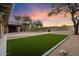 Expansive backyard with artificial turf, flagstone path, fire pit, and desert landscaping at 7628 E Mary Sharon Dr, Scottsdale, AZ 85266