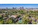 Aerial view showcasing a house, pool, and lush landscaping with a city backdrop at 363 E Monte Vista Rd, Phoenix, AZ 85004