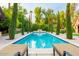 Stunning pool with a stone fountain and tall trees lining the sides at 363 E Monte Vista Rd, Phoenix, AZ 85004