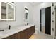 Stylish bathroom with double vanity, modern fixtures, wooden cabinets, and an illuminated mirror at 2136 E Paradise Ln, Phoenix, AZ 85022