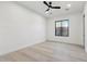 Bright bedroom featuring light wood floors, modern ceiling fan, and a window providing natural light at 2136 E Paradise Ln, Phoenix, AZ 85022