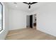 Bright bedroom with wood flooring, a modern ceiling fan, and a view into the connected bathroom at 2136 E Paradise Ln, Phoenix, AZ 85022