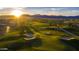 Scenic golf course view with mountain backdrop, lush greens, sand traps and picturesque community at sunset at 12075 N San Clemente St, Surprise, AZ 85388
