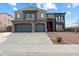 Two-story house with gray exterior, two-car garage, and red front door at 12943 W Mclellan Rd, Glendale, AZ 85307