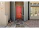 Charming front entrance showcasing a vibrant red door, stone tile walkway, and meticulously maintained landscaping at 12943 W Mclellan Rd, Glendale, AZ 85307