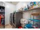 Functional laundry room with modern washer and dryer, storage shelves, and tiled floors at 12943 W Mclellan Rd, Glendale, AZ 85307