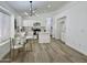 Bright kitchen and dining area boasts modern lighting, white cabinets, and hardwood floors at 5984 W Geronimo Ct, Chandler, AZ 85226