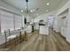 Sunlit kitchen features a modern chandelier, white cabinets, and an island at 5984 W Geronimo Ct, Chandler, AZ 85226