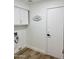 Clean laundry room with white cabinets, decor sign, and wood-look flooring at 5984 W Geronimo Ct, Chandler, AZ 85226