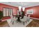 Bright dining room with a dark wood table, white chairs, and red accent wall at 1553 E Zion Way, Chandler, AZ 85249