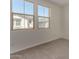 Bedroom featuring neutral carpet and large windows with views to a home next door at 2878 N Evergreen St, Buckeye, AZ 85396