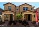 Close exterior view of tan homes showcasing covered entries, dark doors, and landscaping at 2878 N Evergreen St, Buckeye, AZ 85396