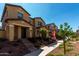 Exterior view of tan two-story home with inviting front yard and landscaping at 2878 N Evergreen St, Buckeye, AZ 85396