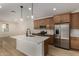 Modern kitchen features stainless appliances, island with pendant lighting, and ample counter space at 2878 N Evergreen St, Buckeye, AZ 85396