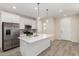 Bright kitchen with stainless steel appliances, a center island, and wood-look flooring at 2888 N Evergreen St, Buckeye, AZ 85396