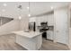Open kitchen with stainless steel appliances, a center island, and wood-look flooring at 2888 N Evergreen St, Buckeye, AZ 85396