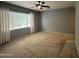 Neutral bedroom featuring a ceiling fan, plush carpeting, and a window with privacy blinds and light-filtering curtains at 12956 W El Sueno Ct, Sun City West, AZ 85375