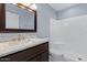Bathroom with a white shower-tub and a dark vanity with a marble countertop at 2409 E Hampton Ave, Mesa, AZ 85204