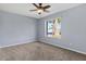 Spacious bedroom featuring plush carpeting, a ceiling fan, and a bright window view at 2409 E Hampton Ave, Mesa, AZ 85204