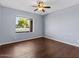 Bedroom featuring wood flooring, a ceiling fan, and a bright window view at 2409 E Hampton Ave, Mesa, AZ 85204