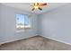 This bedroom features neutral carpet, a window for natural light and a ceiling fan at 2409 E Hampton Ave, Mesa, AZ 85204