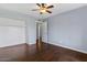 Bright bedroom with wood flooring, ceiling fan, closet, and door to another room at 2409 E Hampton Ave, Mesa, AZ 85204