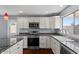 Well-equipped kitchen with stainless steel appliances, granite countertops, and modern white cabinetry at 2409 E Hampton Ave, Mesa, AZ 85204