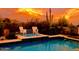 Inviting backyard pool area with stylish patio furniture and desert landscaping at sunset at 4333 S Pony Rider Trl, Gold Canyon, AZ 85118