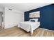 Bedroom with blue accent wall, wood floors, double closets, and ample natural light at 10224 E Michigan Ave, Sun Lakes, AZ 85248