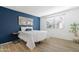 Bedroom showcasing a blue accent wall, wood floors, and a large window for natural light at 10224 E Michigan Ave, Sun Lakes, AZ 85248