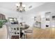 Bright dining room with wood look floors and chandelier open to living area and kitchen at 10224 E Michigan Ave, Sun Lakes, AZ 85248