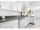Close-up of the kitchen with granite countertops, white cabinets, and modern stainless steel dishwasher at 10224 E Michigan Ave, Sun Lakes, AZ 85248