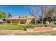 Welcoming Heritage Club house with a manicured lawn and mature trees at 15409 W Corrine Dr, Surprise, AZ 85379
