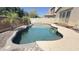 Sparkling backyard pool with stone border and privacy wall, perfect for outdoor entertaining at 15409 W Corrine Dr, Surprise, AZ 85379